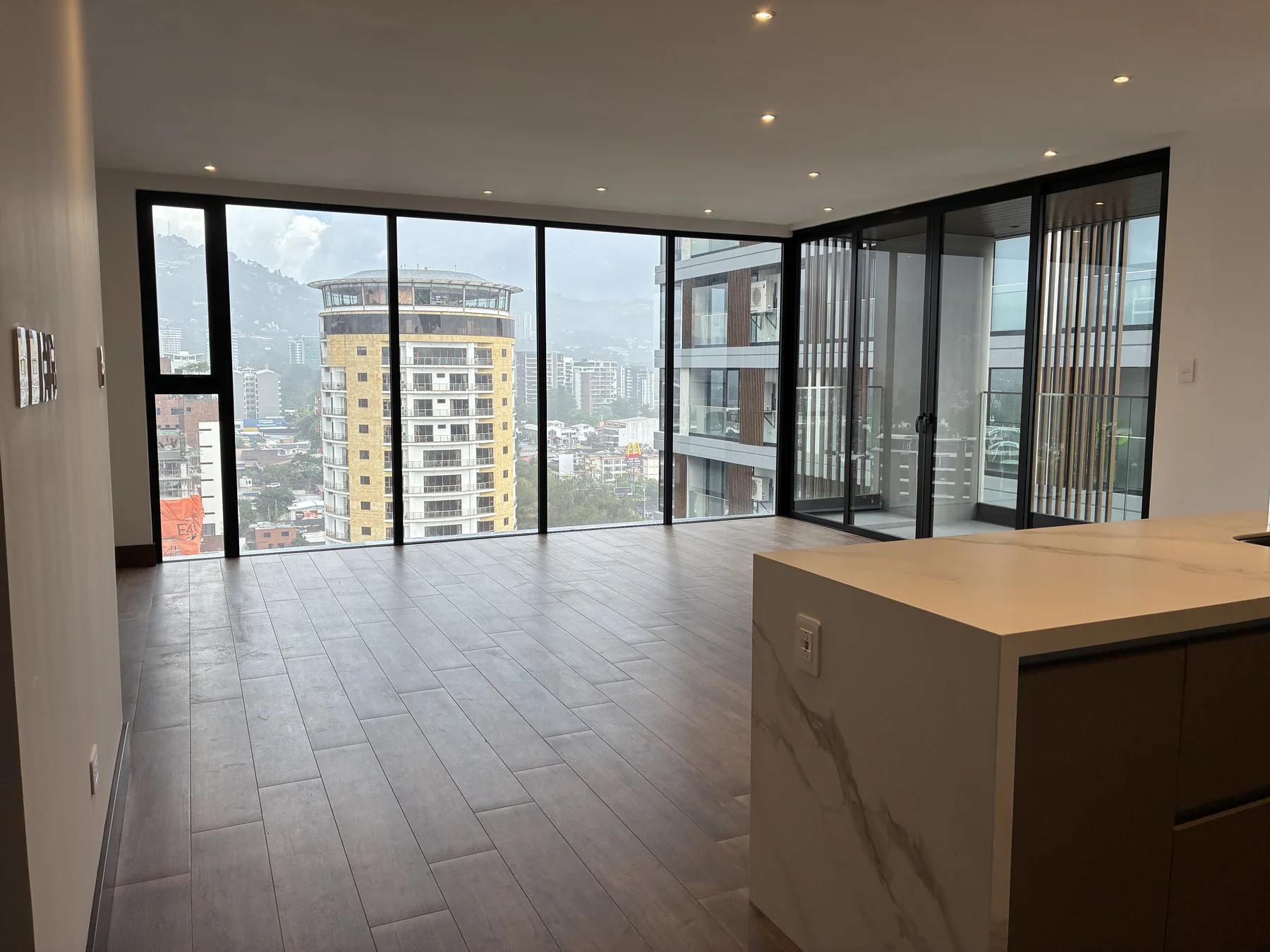 Sala amplia, ventanales y balcón de GAURA N-1601 vistos desde la cocina